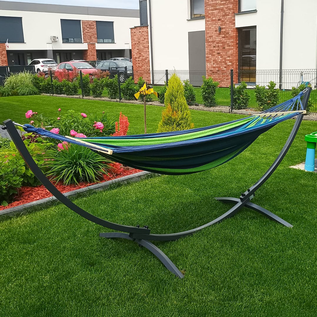 Outdoor-Hängematte mit stabilem Gestell auf gepflegtem Rasen vor modernem Wohnhaus mit Blumenbeet