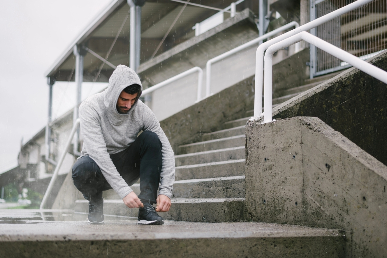 Sportler bereitet sich bei Regen und kaltem Herbstwetter auf Outdoor-Training vor