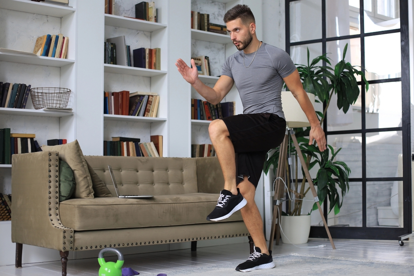 Mann macht intensives HIIT-Training zu Hause im Wohnzimmer – kurzes 20-Minuten-Workout für die Feiertage